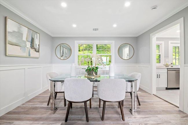 Dining area with a decorative wall, crown molding, wainscoting, recessed lighting, and light wood-type flooring | Image 6