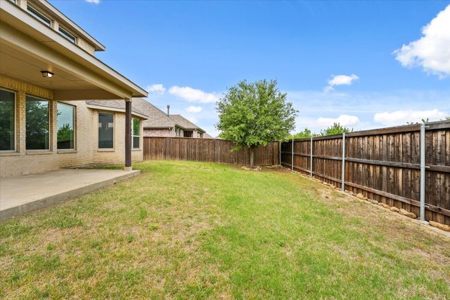 The yard is large and has a wooden privacy fence. | Image 31