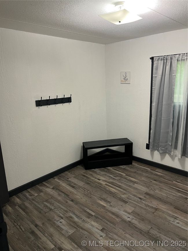 Spare room with dark wood-type flooring and baseboards | Image 20