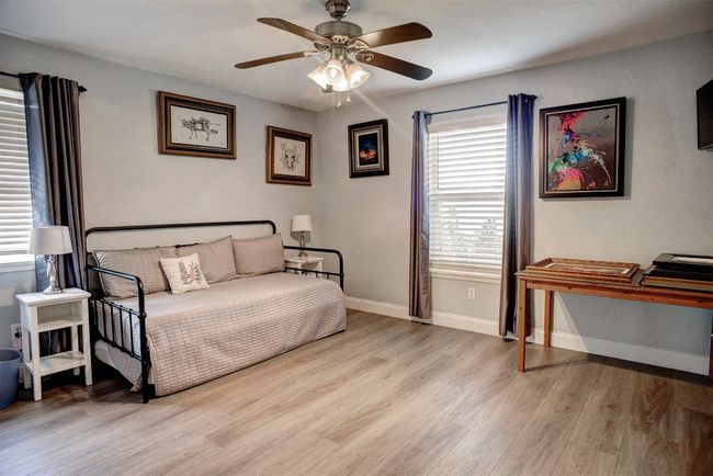 Bedroom with multiple windows, vinyl floors, and ceiling fan | Image 22