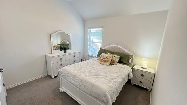 Bedroom 2 with dark colored carpet, lofted ceiling, and baseboards | Image 23