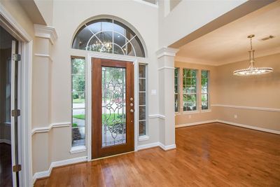 Soaring ceilings throughout are just one of the most captivating features of this home, as enjoyed here in the interior view of the front entry with facing front rooms to fill. At right, is the beautiful formal dining area. Opposite it, on the other side of the magnificent foyer, is a probable home office/study behind classic french doors. | Image 3