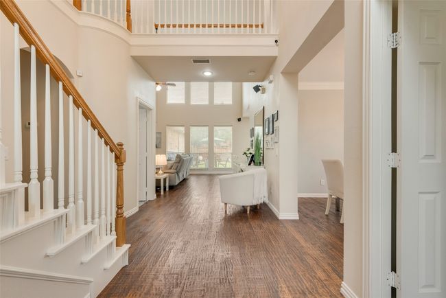 Foyer entrance with a high ceiling, stairs, baseboards, and dark wood-style floors | Image 5