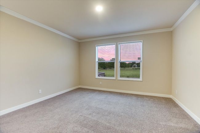 Carpeted spare room with crown molding and baseboards | Image 20