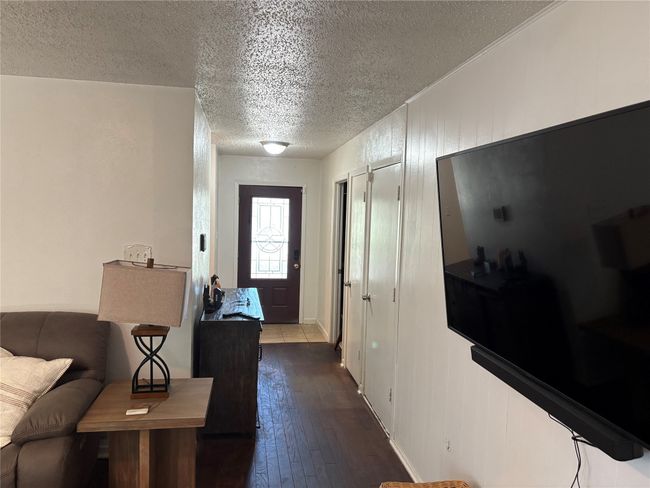 Foyer featuring a textured ceiling and dark wood-style floors | Image 5