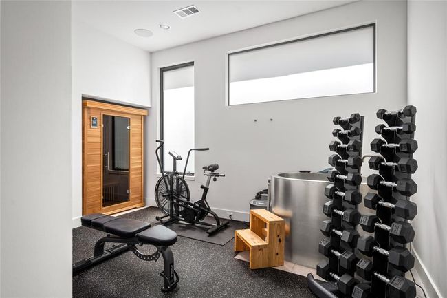 This dedicated wellness room is fully equipped for serious training, featuring rubber flooring, free weights, cardio equipment, a cold plunge, and an infrared sauna—offering a private wellness experience just steps from your living space. | Image 26