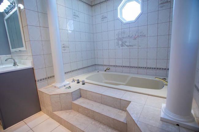 Bathroom with tile patterned floors, tiled bath, vanity, and tile walls | Image 15