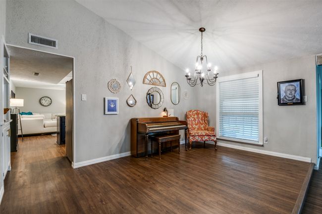 Sitting room with a notable chandelier, and wood-style floors | Image 10