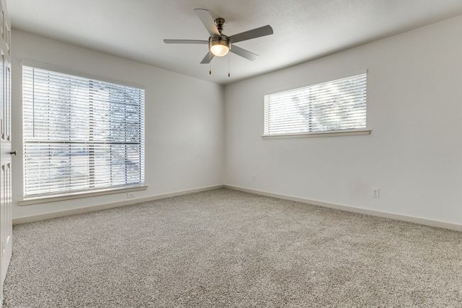 Carpeted empty room with ceiling fan and plenty of natural light | Image 30