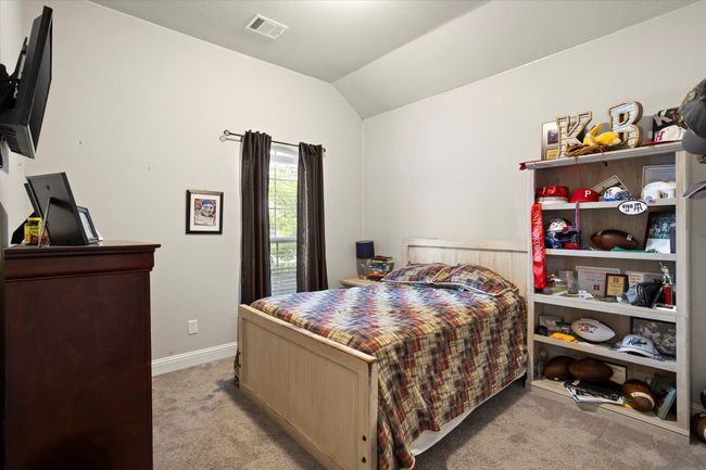 Bedroom featuring vaulted ceiling, light carpet, visible vents, and baseboards | Image 10