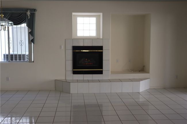Detailed view of a tiled fireplace and a chandelier | Image 27