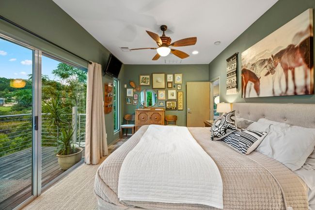 Glass walled primary bedroom has a private balcony. | Image 33