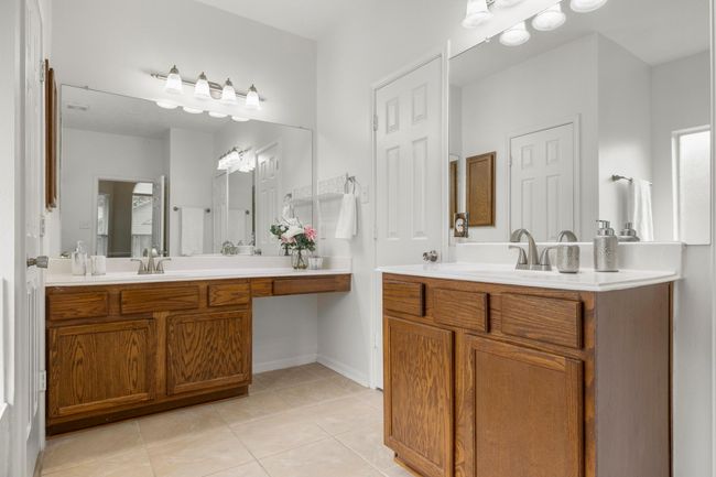 Dual vanities, ample lighting, and a built-in makeup counter add both function and flexibility to the primary bath. | Image 20