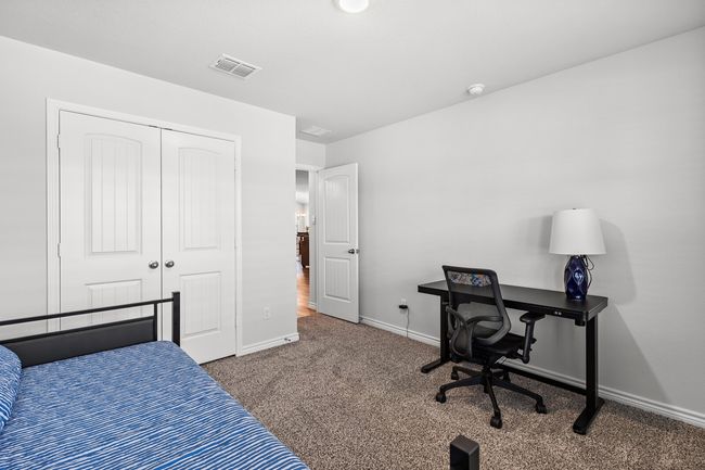 Bedroom featuring carpet floors, a closet, and an office area | Image 28