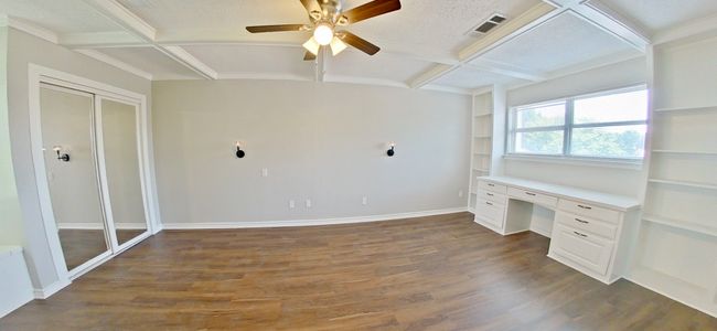 Unfurnished office featuring visible vents, built in desk, coffered ceiling, wood finished floors, and ceiling fan | Image 14