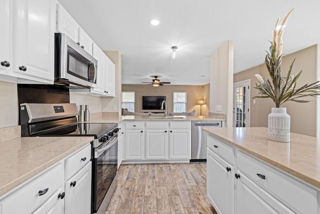 The fully updated kitchen is a chef’s dream, featuring sleek quartz countertops and ample workspace for cooking and entertaining. | Image 6