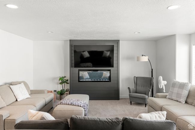 Living room featuring recessed lighting, a textured ceiling, a fireplace, and carpet flooring | Image 19