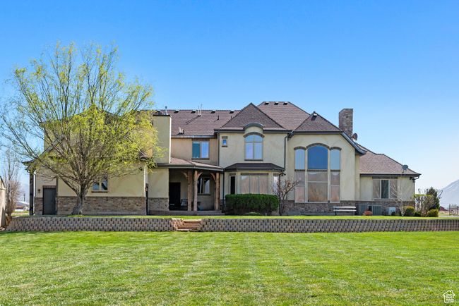 View of front of property featuring a front yard, stucco siding, and a chimney | Image 6