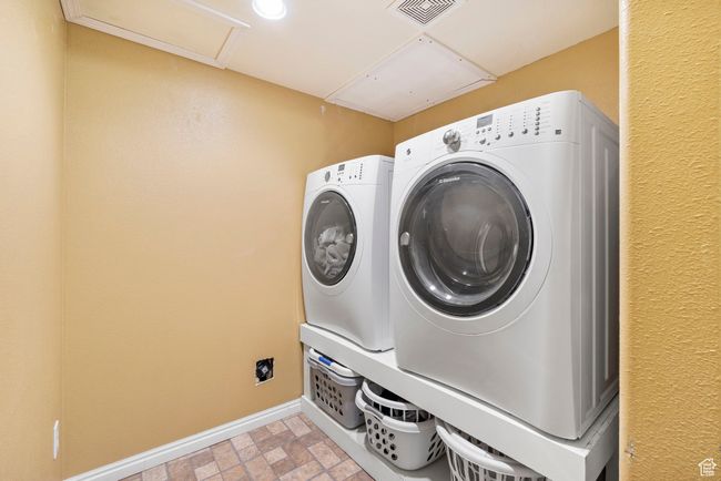 Laundry area featuring brick floor, laundry area, washing machine and dryer, baseboards, and visible vents | Image 32