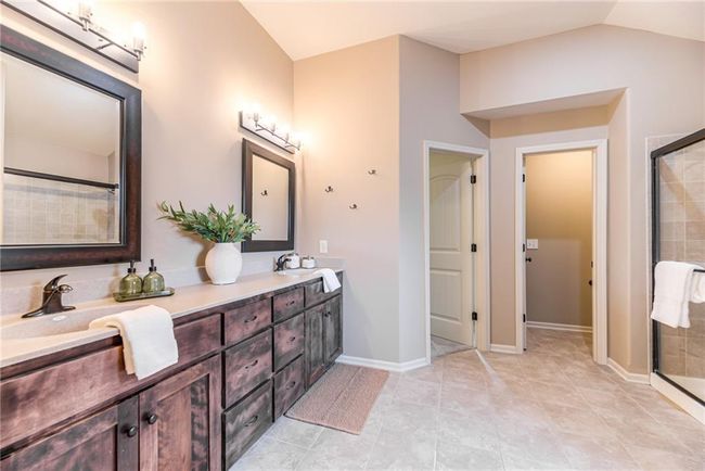 Bathroom with double vanity, a stall shower, and tile patterned floors | Image 26
