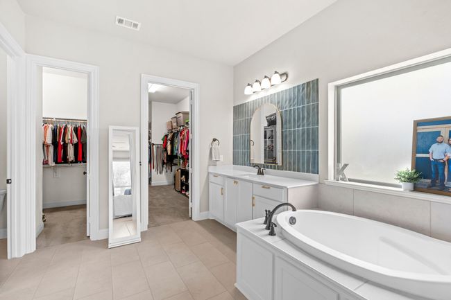 Full bathroom featuring a spacious closet, a bath, vanity, and tile patterned flooring | Image 24