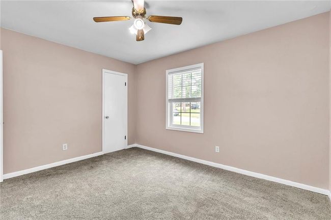 Carpeted empty room with a ceiling fan and baseboards | Image 31
