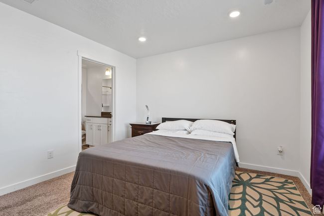 Carpeted bedroom featuring recessed lighting, baseboards, and ensuite bathroom | Image 9