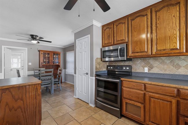Kitchen featuring ceiling fan, a healthy amount of sunlight, double oven range, and tasteful backsplash | Image 20