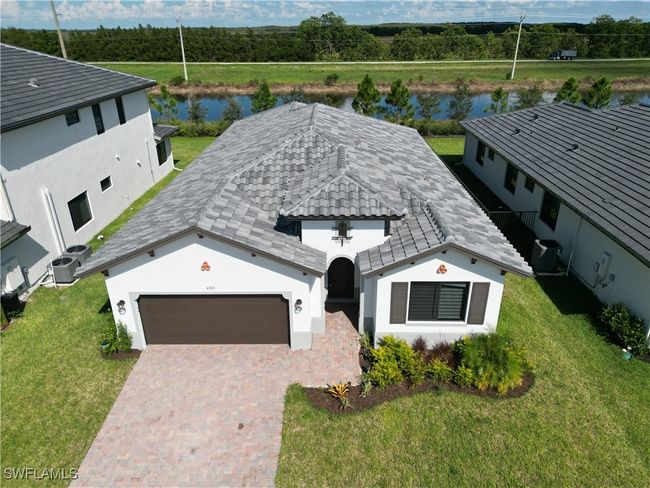 View of front of property featuring a front yard, a water view, and a garage | Image 7