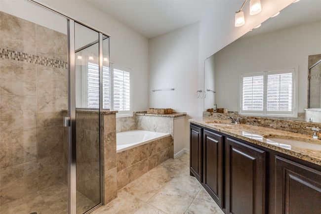 Primary bathroom with separate shower, garden tub, and dual sinks. | Image 17