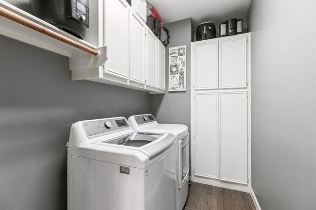 The utility room has ample storage space. It offers upper cabinet space and a clothes hanging rod. Plus, room for a freezer. | Image 39