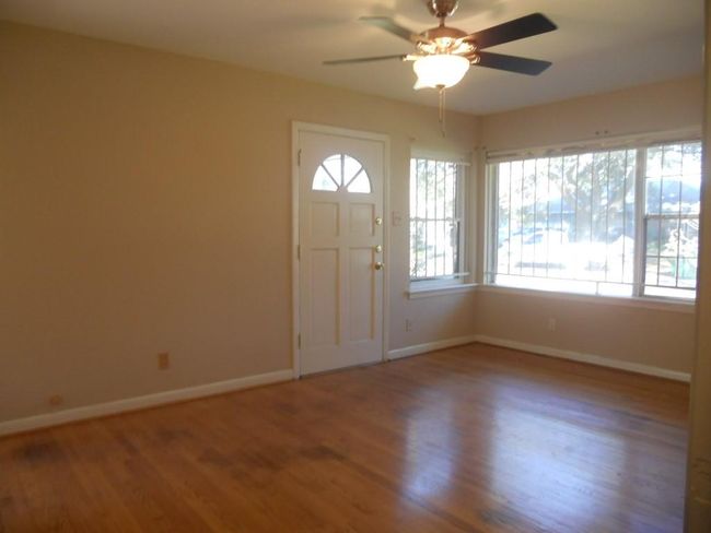 Dining room and/or flex space. It is open to the kitchen and offers access to the backyard. Hardwood floors and updated ceiling fan. The door on the right leads to the laundry area and garage. | Image 5