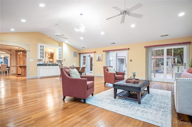 This 29' x 23' Florida room open space with vaulted ceilings, a built-in wet bar, three French doors, and warm hardwoods | Image 21