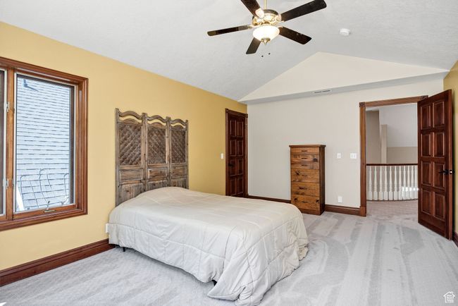 Bedroom with light carpet, lofted ceiling, and a ceiling fan | Image 49