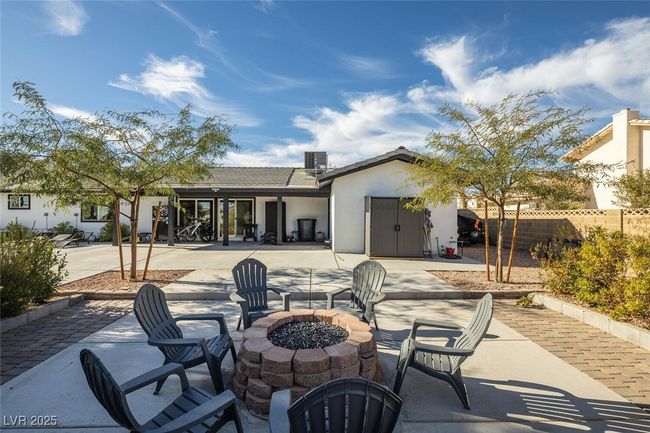 Back of property with stucco siding, fence, an outdoor fire pit, central AC unit, and a patio area | Image 33