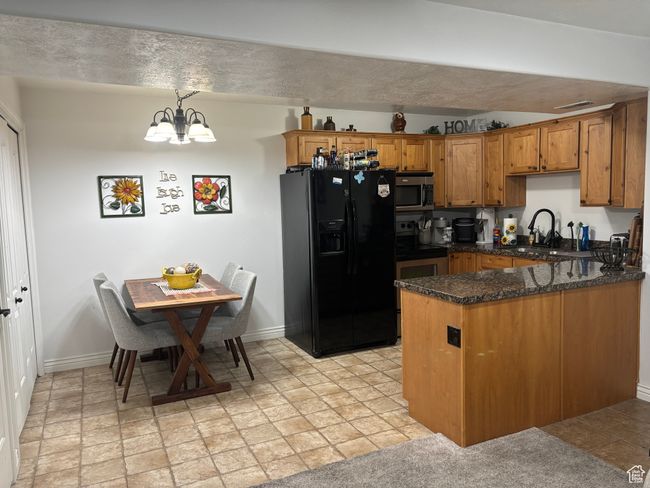 Kitchen featuring appliances with stainless steel finishes, brown cabinets, a peninsula, and baseboards | Image 10