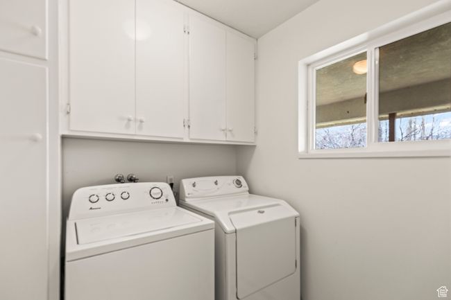 Laundry room with built-in cabinets and window view of the back porch | Image 31