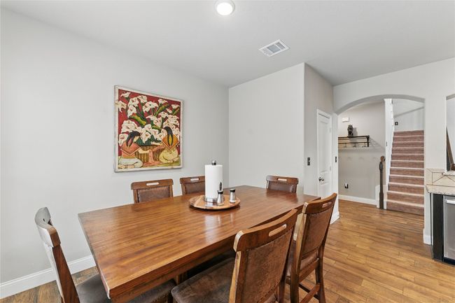 Dining space featuring arched walkways, light wood finished floors, visible vents, and baseboards | Image 17