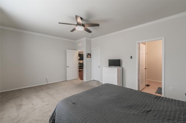 Main bedroom featuring ornamental molding, light carpet, and ceiling fan | Image 28