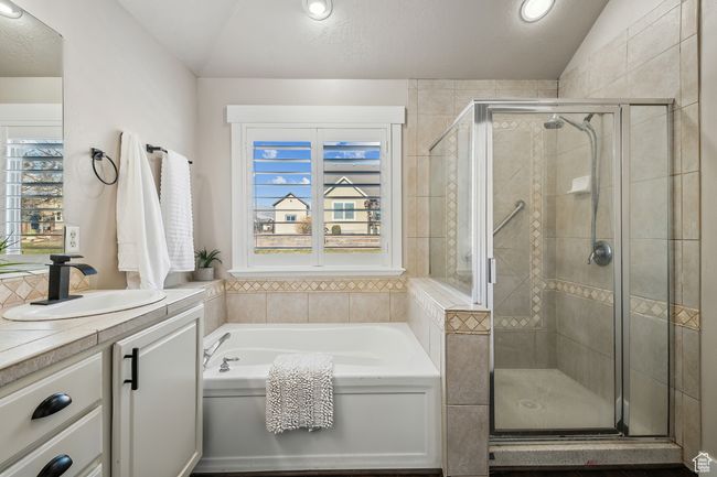 Bathroom featuring separate shower and tub, vaulted ceiling, and vanity | Image 18