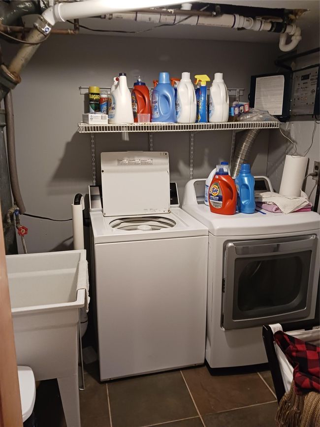 Laundry area with tile patterned floors, separate washer and dryer, laundry area, and a sink | Image 19