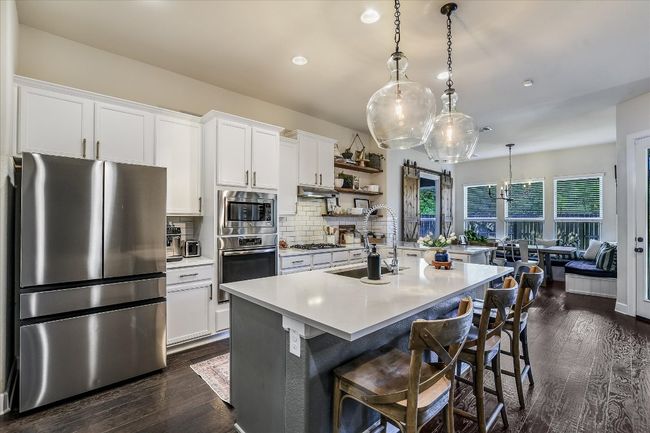 Kitchen featuring tasteful backsplash, light countertops, dark wood finished floors, stainless steel appliances, and a sink | Image 9