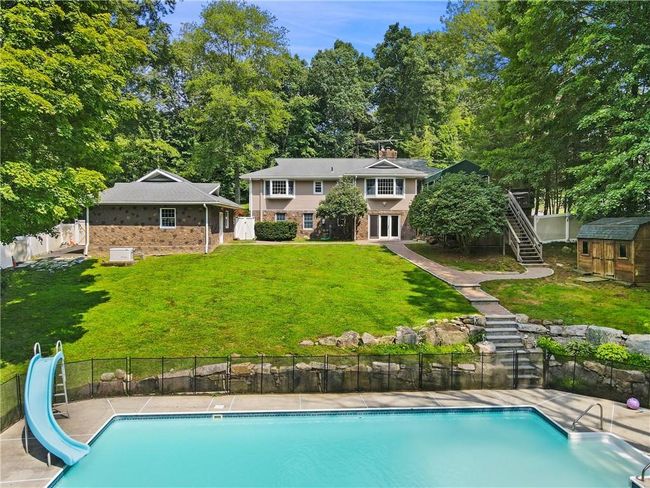 View of pool featuring a water slide and a yard | Image 29