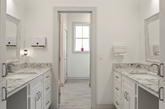 Full bathroom featuring wood finished floors, two vanities, and a sink | Image 20