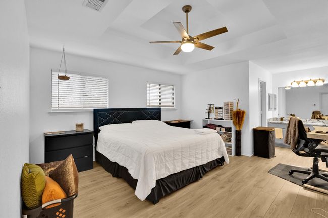 Bedroom with a raised ceiling and light wood-style floors | Image 18