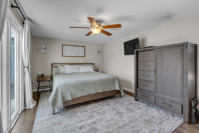 Bedroom with a ceiling fan, wood finished floors, and baseboards | Image 5