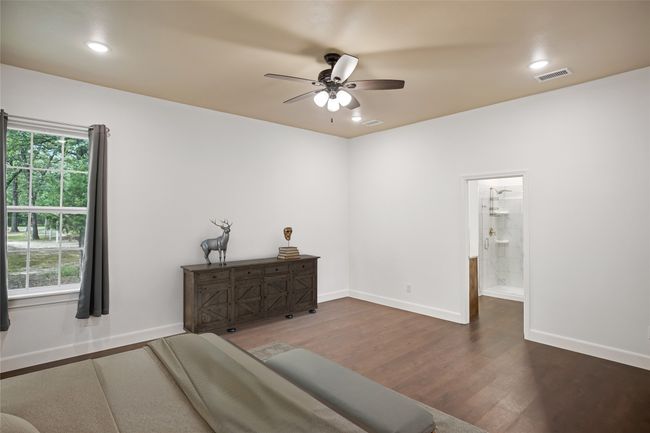 Bedroom with wood finished floors, multiple windows, recessed lighting, a ceiling fan, and connected bathroom | Image 15
