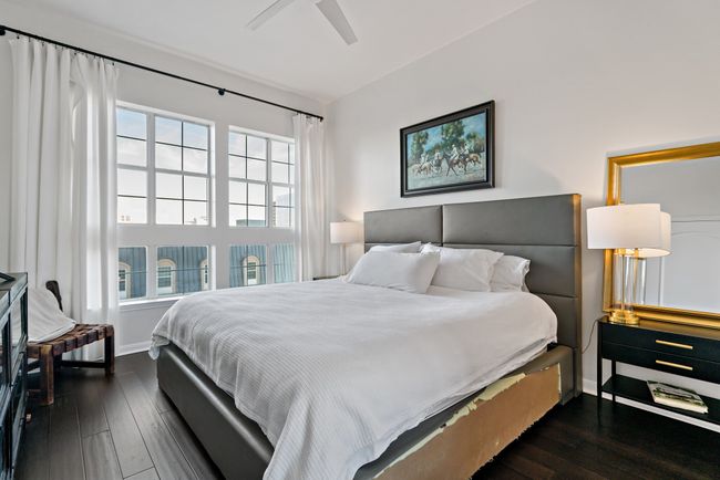 Bedroom with a ceiling fan, baseboards, and dark wood-style floors | Image 13
