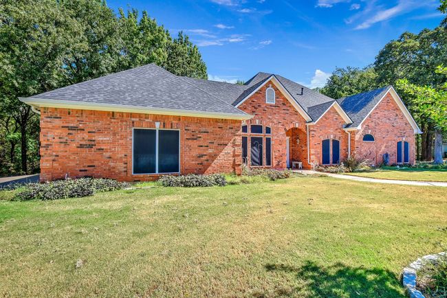View of front facade featuring brick siding, roof with shingles, and a front yard | Image 31