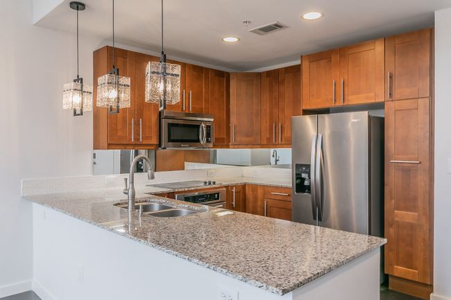Cook, entertain, and connect in this stunning kitchen featuring granite countertops, stainless appliances, and a spacious island that opens seamlessly into the main living area. | Image 4